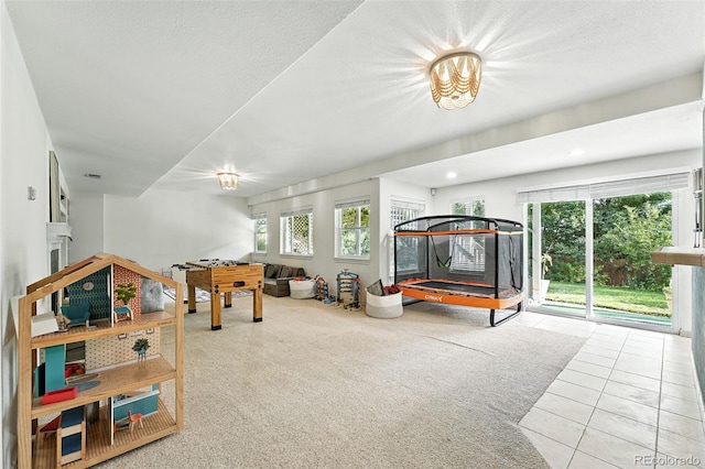 5731 S Yampa St, Centennial, CO 80015 - recreation room with tile patterned floors, a glass covered fireplace, and carpet floors