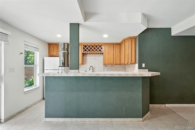 5731 S Yampa St, Centennial, CO 80015 - kitchen with tile countertops, freestanding refrigerator, backsplash, recessed lighting, and brown cabinetry