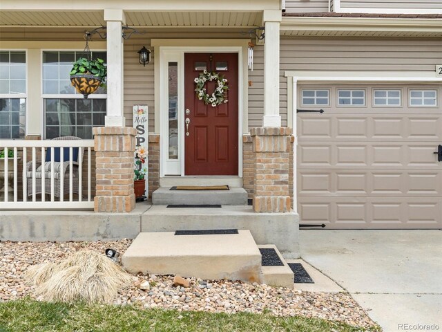 2468 Candleglow St, Castle Rock, CO 80109 - view of exterior entry featuring a garage, concrete driveway, and covered porch