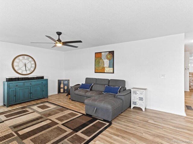 2468 Candleglow St, Castle Rock, CO 80109 - living room featuring ceiling fan, light wood-type flooring, a textured ceiling, and baseboards