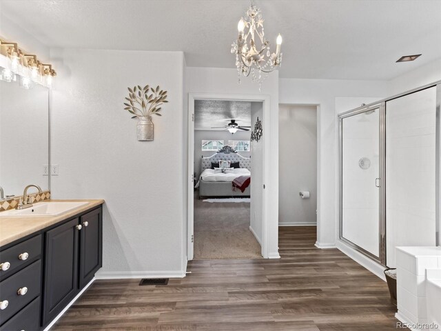 2468 Candleglow St, Castle Rock, CO 80109 - ensuite bathroom featuring vanity, a stall shower, wood finished floors, baseboards, and a chandelier