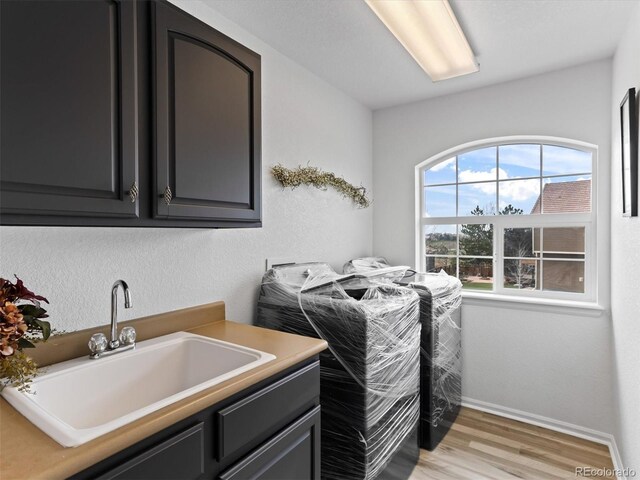 2468 Candleglow St, Castle Rock, CO 80109 - laundry room featuring cabinet space, light wood finished floors, baseboards, and independent washer and dryer