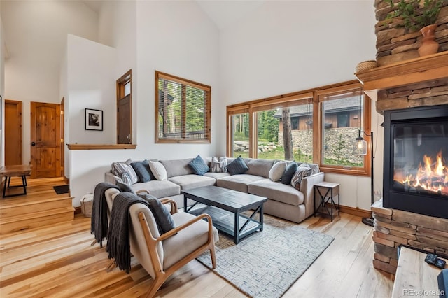 1152 Ski Hill Rd, Breckenridge, CO 80424 - living room featuring high vaulted ceiling, a stone fireplace, and light wood-style floors