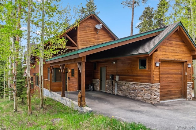 1152 Ski Hill Rd, Breckenridge, CO 80424 - view of front of home featuring stone siding, asphalt driveway, and a garage