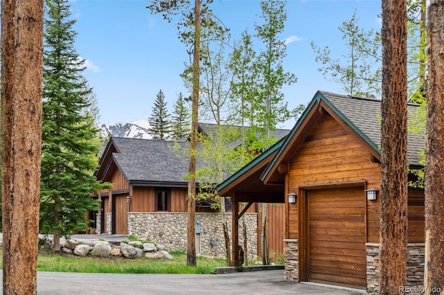 1152 Ski Hill Rd, Breckenridge, CO 80424 - view of front of property with stone siding, roof with shingles, a garage, and asphalt driveway