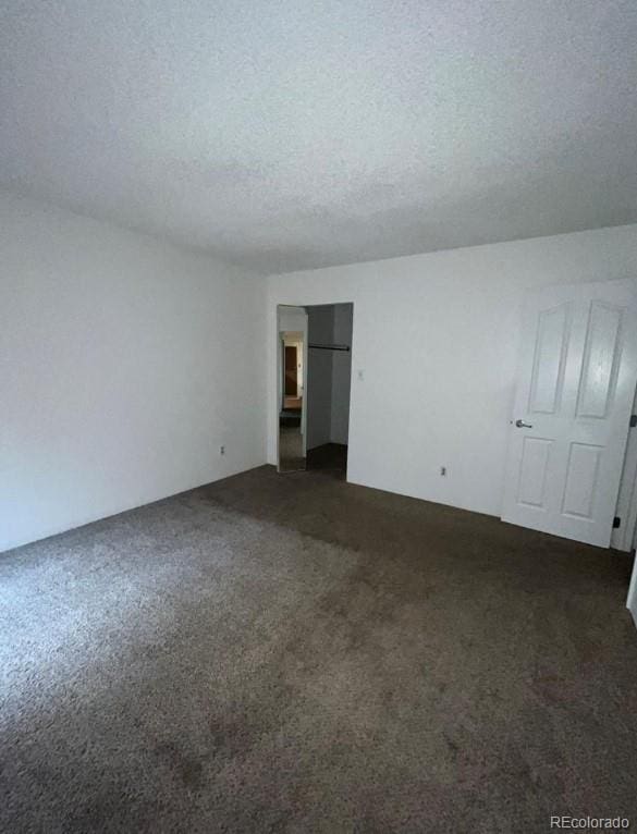 carpeted empty room with a textured ceiling