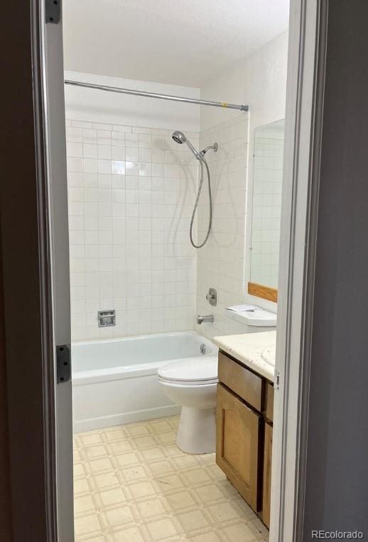 full bathroom featuring tiled shower / bath combo, vanity, and toilet