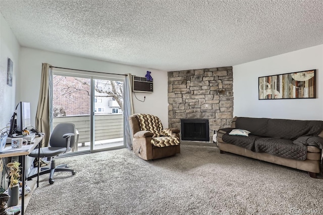 office with a wall mounted air conditioner, a stone fireplace, a textured ceiling, and carpet flooring