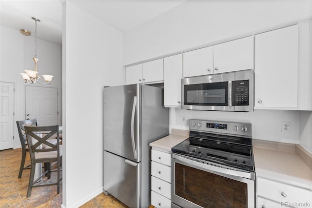 kitchen featuring white cabinets, hanging light fixtures, appliances with stainless steel finishes, and light tile patterned floors