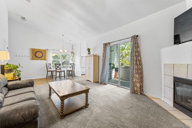 living room with a tiled fireplace, high vaulted ceiling, a wealth of natural light, and an inviting chandelier