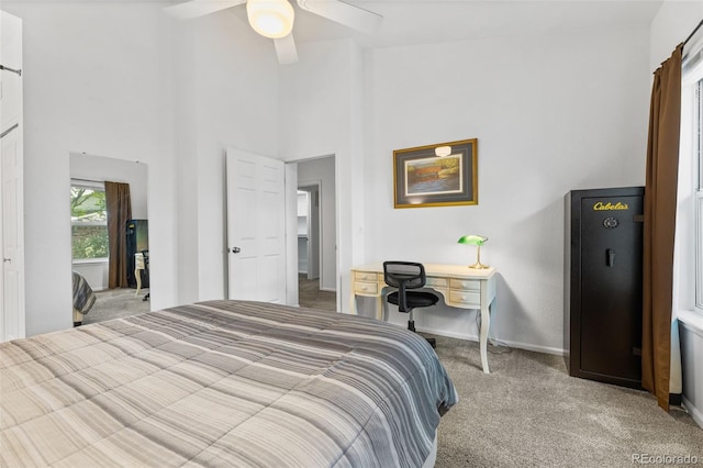 carpeted bedroom featuring high vaulted ceiling and ceiling fan