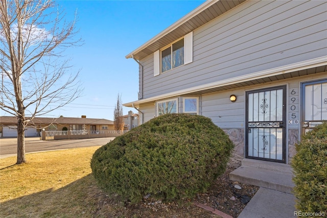 view of exterior entry with a lawn