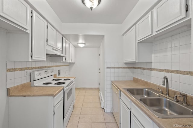 kitchen with a sink, under cabinet range hood, white appliances, light countertops, and light tile patterned floors