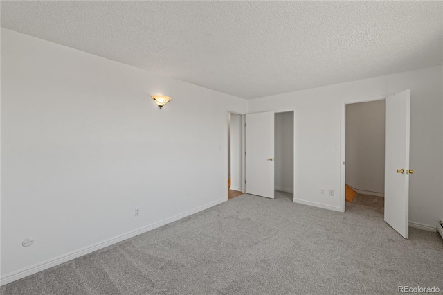 unfurnished bedroom featuring baseboards, a textured ceiling, and carpet flooring