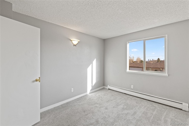 empty room featuring a baseboard heating unit, carpet, baseboards, and a textured ceiling