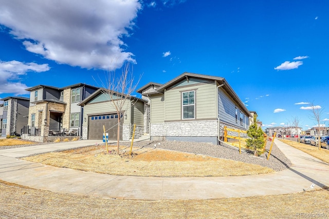 view of front of property with a garage, stone siding, and driveway