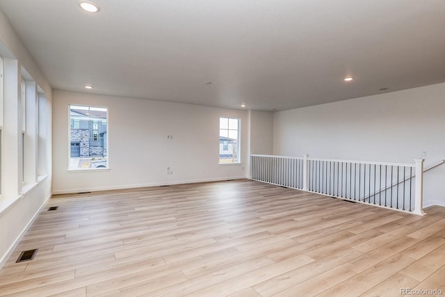 spare room with recessed lighting, visible vents, light wood-style flooring, and baseboards