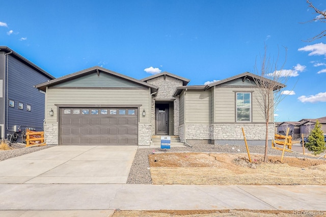 view of front of property with a garage, stone siding, and driveway