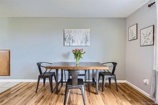 dining room featuring baseboards and light wood finished floors