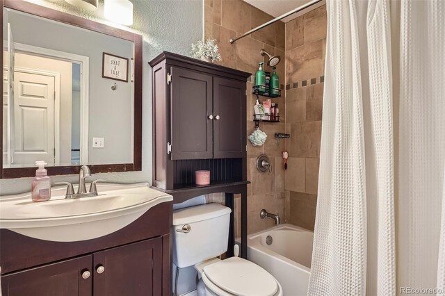 full bathroom with toilet, shower / bathtub combination with curtain, and vanity