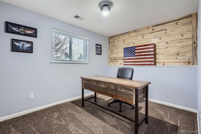 carpeted home office with visible vents, a textured ceiling, and baseboards