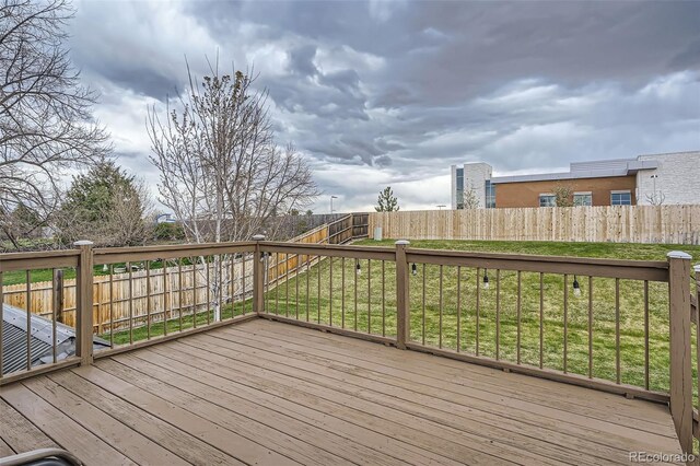 wooden deck featuring a fenced backyard and a yard