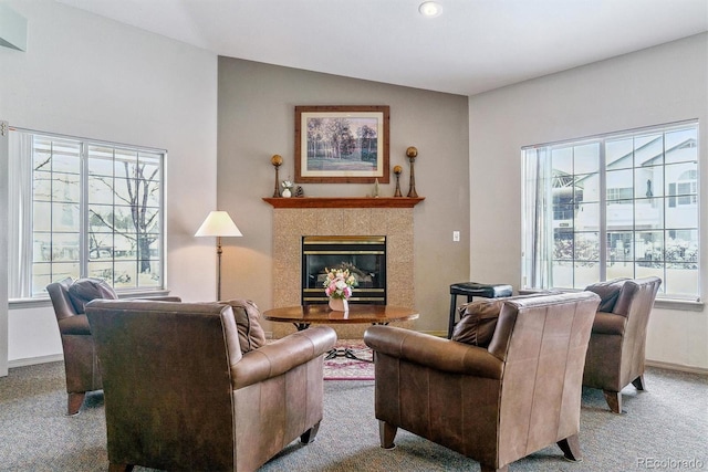 carpeted living room with vaulted ceiling, a wealth of natural light, and a tile fireplace