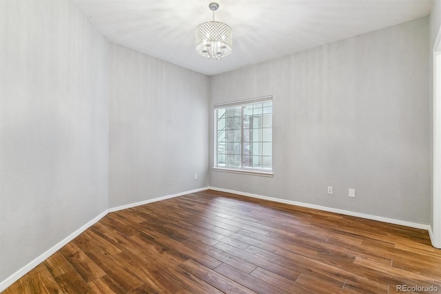 unfurnished room with hardwood / wood-style flooring and a notable chandelier