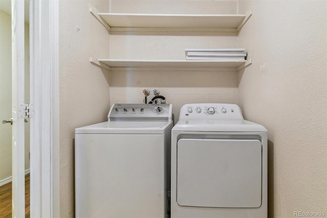 laundry area with independent washer and dryer and hardwood / wood-style flooring