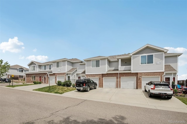 10129 W 55th Dr Unit 3, Arvada, CO 80002 - view of property featuring brick siding, driveway, a garage, and a residential view