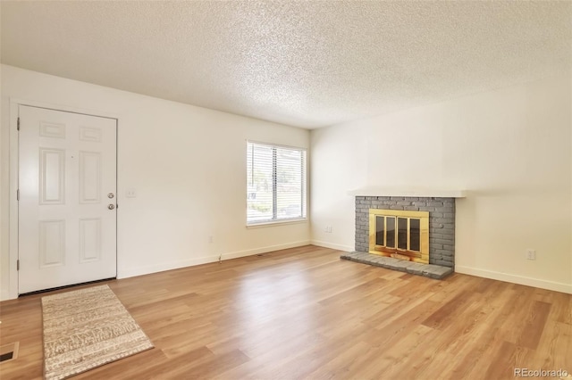 4182 S Joplin St, Aurora, CO 80013 - unfurnished living room with a textured ceiling, light wood-style floors, a fireplace, and baseboards