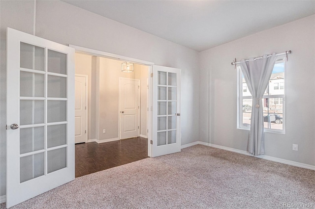 carpeted spare room featuring french doors