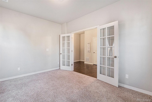 empty room featuring french doors and dark carpet