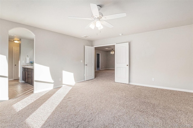 empty room with light colored carpet and ceiling fan