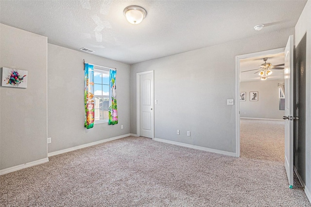 spare room with light carpet, a textured ceiling, and ceiling fan