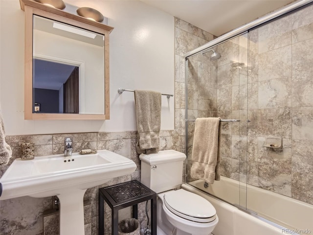 1540 W Briarwood Ave, Littleton, CO 80120 - full bath featuring combined bath / shower with glass door, toilet, tile walls, wainscoting, and a sink