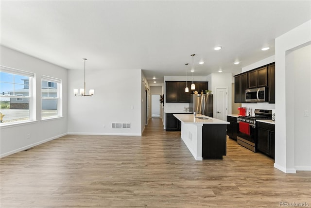 15501 E 112th Ave Unit 6F, Commerce City, CO 80022 - kitchen with stainless steel appliances, a chandelier, recessed lighting, light countertops, and light wood finished floors