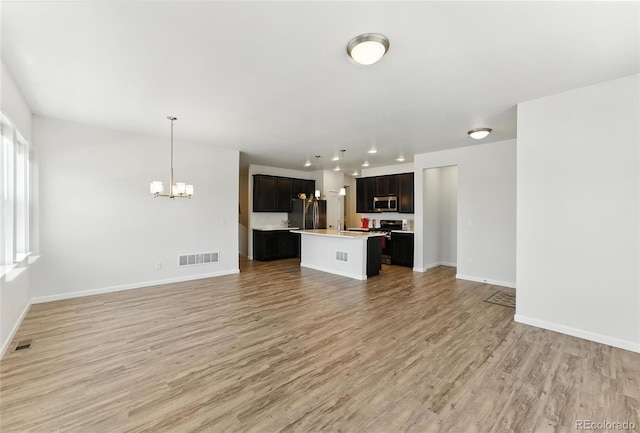 15501 E 112th Ave Unit 6F, Commerce City, CO 80022 - unfurnished living room featuring a chandelier and light wood-style floors