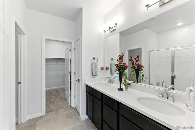 15501 E 112th Ave Unit 6F, Commerce City, CO 80022 - bathroom featuring double vanity, a spacious closet, and a stall shower