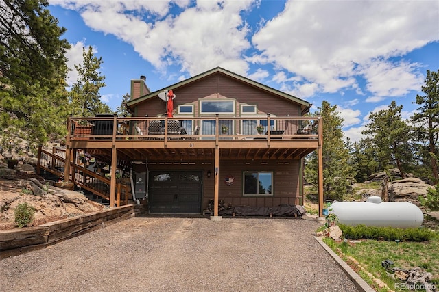 61 Country Sky Ln, Estes Park, CO 80517 - rustic home with an attached garage, driveway, a chimney, and a deck