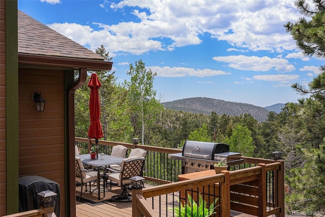 61 Country Sky Ln, Estes Park, CO 80517 - wooden terrace featuring outdoor dining area, a mountain view, a forest view, and a grill