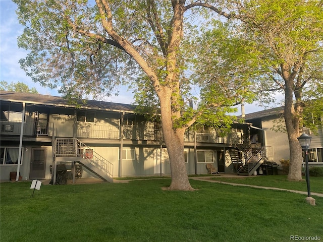 back of property featuring a lawn and a deck