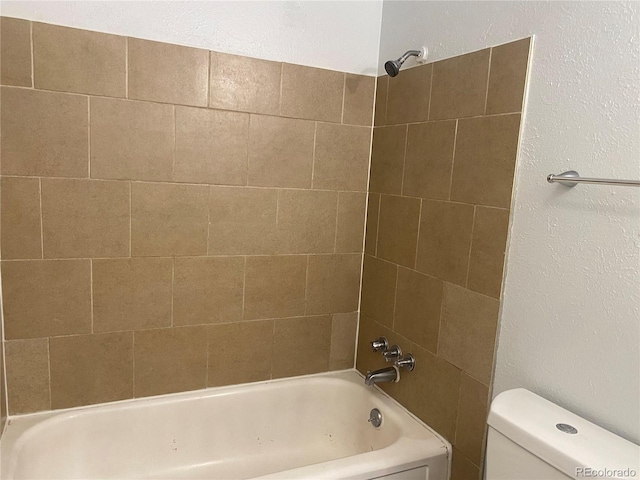 bathroom featuring toilet and tiled shower / bath combo