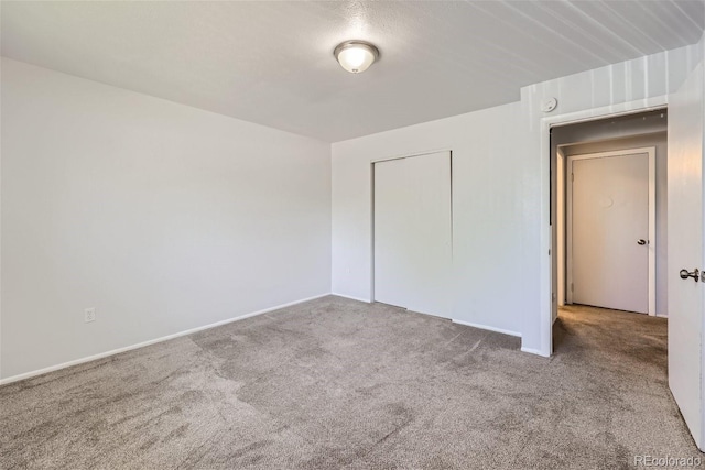 unfurnished bedroom featuring light carpet and a closet