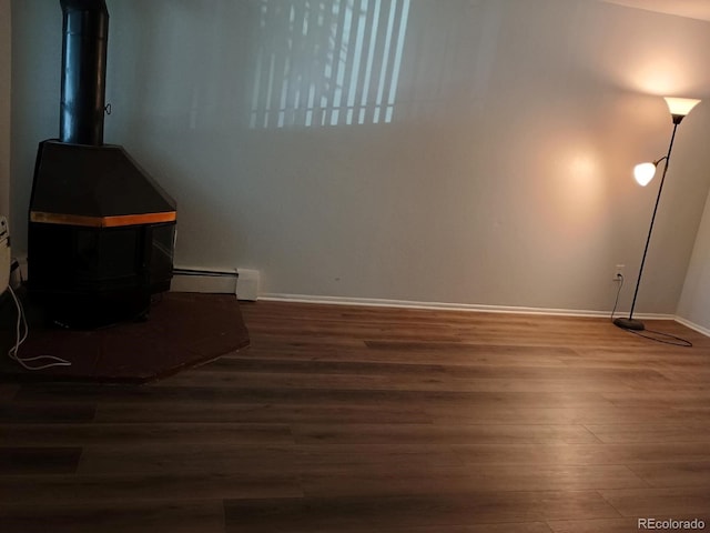 interior space featuring a baseboard radiator, a wood stove, and dark hardwood / wood-style floors