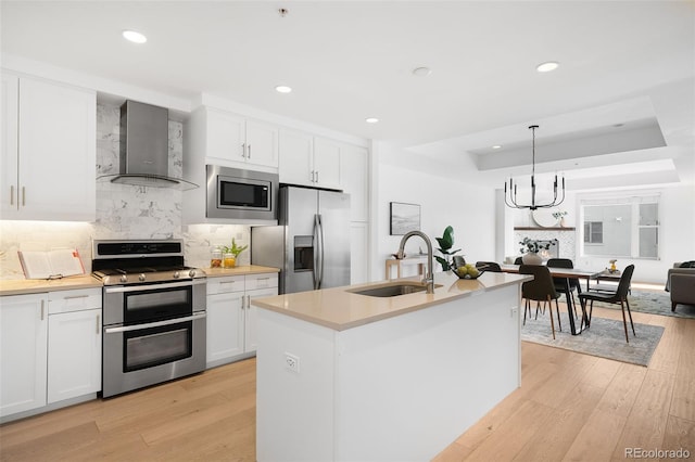 3301 Arapahoe Ave Unit 411, Boulder, CO 80303 - kitchen with appliances with stainless steel finishes, wall chimney exhaust hood, backsplash, light countertops, and white cabinets