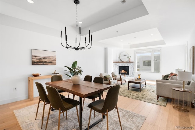 3301 Arapahoe Ave Unit 411, Boulder, CO 80303 - dining room with a raised ceiling, a chandelier, light wood-style floors, a tile fireplace, and recessed lighting