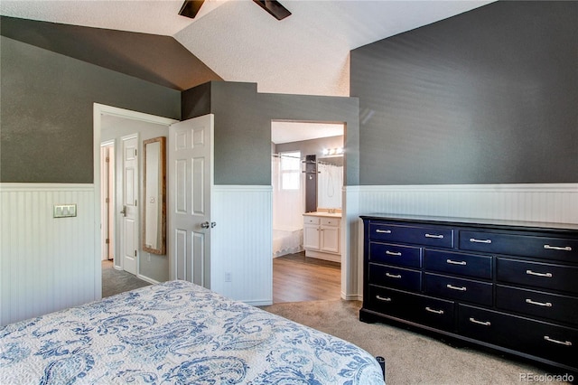 4483 S Fundy St, Centennial, CO 80015 - carpeted bedroom featuring wainscoting, lofted ceiling, connected bathroom, and ceiling fan