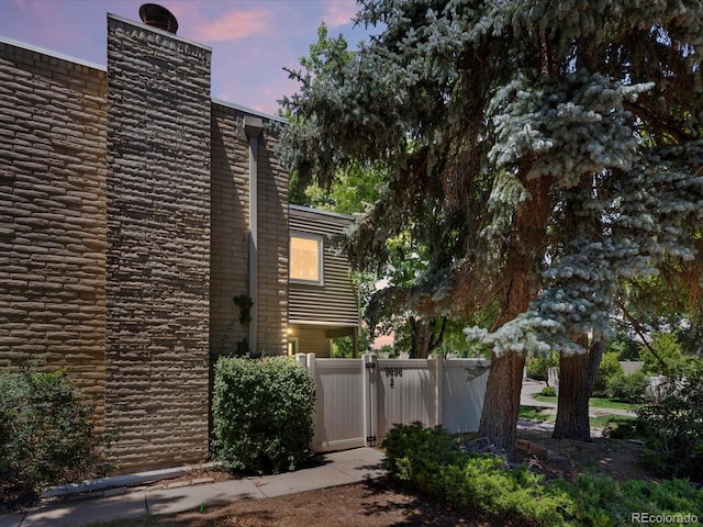9696 E Kansas Cir Unit 2, Denver, CO 80247 - view of home's exterior featuring a chimney and a gate