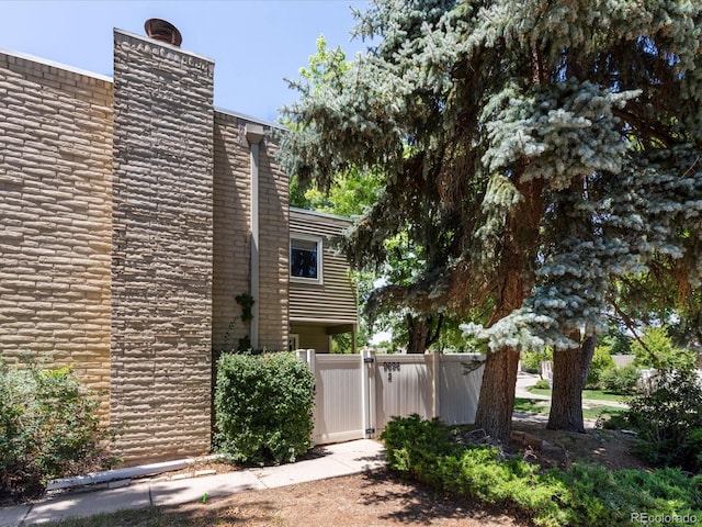 9696 E Kansas Cir Unit 2, Denver, CO 80247 - view of side of property with a chimney and a gate